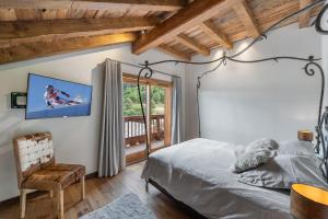 a bedroom with a bed and a balcony at Le Cheval Blanc Luxe, skis aux pieds, jacuzzi, hammam, salle de cinéma in Les Allues