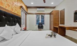 a bedroom with a large white bed and a desk at FabHotel Luck Inn Residency in Chennai