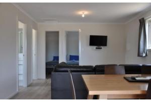 a living room with a couch and a tv on the wall at Discovery Parks - Kangaroo Island in Flinders Chase