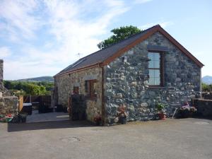 LlandwrogにあるBwthyn Meulanの窓のある小さな石造りの建物