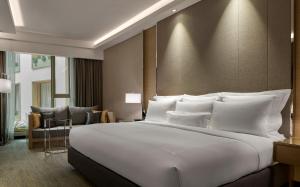 a large white bed in a hotel room at JW Marriott Kuala Lumpur in Kuala Lumpur