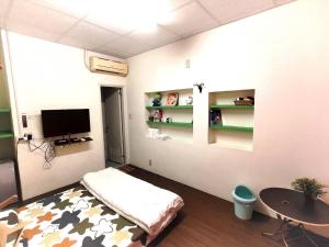 a room with a bed and a table and a tv at 想來就來-台南包棟民宿-電動麻將ktv可寵物 in Tainan