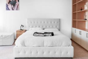a bedroom with a white bed with two towels on it at Moncler House Navigli in Milan