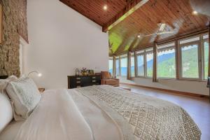 una camera da letto con un letto grande in una stanza con finestre di SaffronStays Kasauli Estate a Kasauli