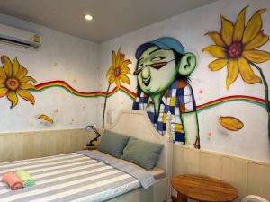een slaapkamer met een schilderij van een man aan de muur bij Hostel and Music Bar Bros in Pai