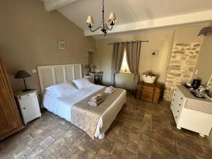 Un dormitorio con una gran cama blanca y una ventana en Le Mas du Père Jean, en Roche-Saint-Secret