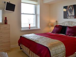 - une chambre avec un grand lit et une fenêtre dans l'établissement Apartment 6, à Ilfracombe