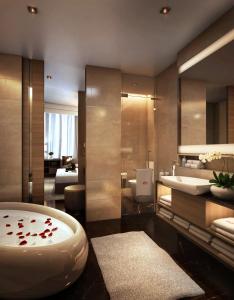 JW Marriott Kuala Lumpur في كوالالمبور: حمام مع حوض استحمام كبير ومغسلة
