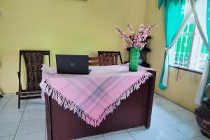 a table with a pink table cloth and a laptop on it at Hotel O Barak Tambunan NearBelawan Port in Medan