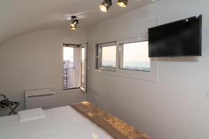 een slaapkamer met een bed en een flatscreen-tv bij EDEL Suite in Chania
