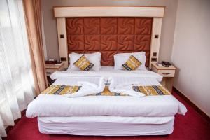 Postel nebo postele na pokoji v ubytování The Luke Hotel Cravers Thika