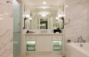 a bathroom with a sink and a tub and a mirror at The Ritz-Carlton, Kuala Lumpur in Kuala Lumpur