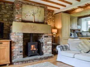 uma sala de estar com lareira e sofá em Fox Cover Cottage em Great Edston