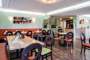 ein Restaurant mit Tischen und Stühlen in einem Raum in der Unterkunft Akzent Hotel Restaurant Hirsch in Heidenheim