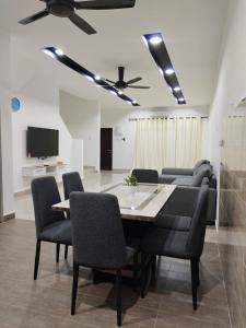 a dining room with a table and chairs and a tv at V-Homestay Bentong in Bentong