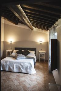 1 dormitorio con 1 cama grande y 2 mesas en Masseria del Bosco - Podere Poderuccio, en Chianciano Terme