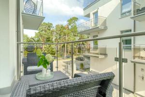 a balcony with a bench and a table at Apartament Doris 2 - 50 m do plaży in Pobierowo