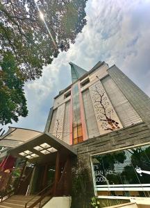 a building with a clock on the side of it at Hemangini Hotel Bandung in Bandung