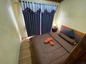 a bedroom with a large bed with blue curtains at D'Yoga Bamboo Cabin in Kintamani