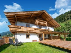 a house with a wooden roof and a deck at beautifully renovated farmhouse Stoanerbauer with a wonderful view in Dorf