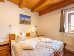 1 dormitorio con cama y ventana en beautifully renovated farmhouse Stoanerbauer with a wonderful view, en Dorf