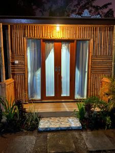 eine Eingangstür eines Hauses in der Nacht in der Unterkunft D'Yoga Bamboo Cabin in Kintamani