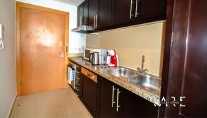 a kitchen with a sink and a counter top at Rare Holiday Homes welcomes you in - Canal View - The links canal Apartment R304 in Dubai