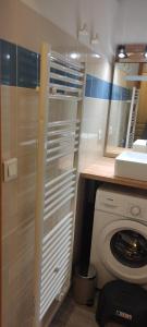 a bathroom with a washing machine and a sink at L'écrin du Bachat Chamrousse in Chamrousse