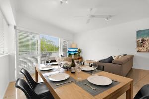 a dining room with a table and chairs and a couch at 1 Riverside in Noosaville