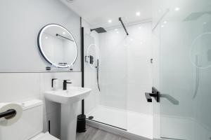 a bathroom with a shower and a sink and a mirror at Craig Manor in Bowness-on-Windermere