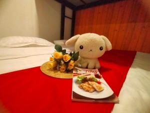 a stuffed animal sitting on a bed with a plate of food at innbox Chiangmai Hotel in Ban Si Ngam +45 photos