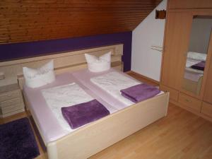 a small bedroom with a large bed with purple sheets at Haus Irmgard in Zell am Harmersbach