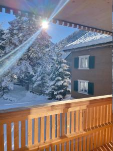 - un balcon avec des arbres enneigés et un bâtiment dans l'établissement Apartment Kanisfluh, à Mellau
