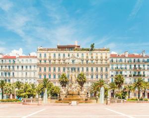 un grande edificio con una fontana di fronte di Superbe appartement proche gare a Tolone