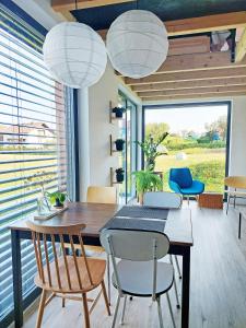 a dining room with a table and chairs and large windows at Small house in a nature park in Log pri Brezovici