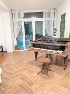 a piano sitting in a living room with a stool at 4 room flat with garden and pool in Kittsee