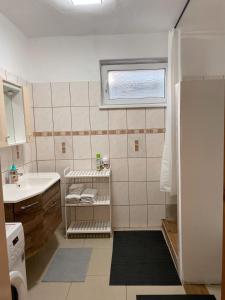a small bathroom with a sink and a window at 4 room flat with garden and pool in Kittsee