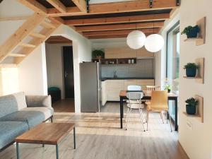 uma sala de estar com uma mesa e uma cozinha em Small house in a nature park em Log pri Brezovici