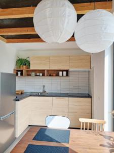 a kitchen with two white lights hanging from the ceiling at Small house in a nature park in Log pri Brezovici