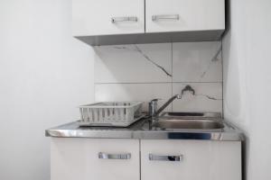 a kitchen sink with a dish drying rack next to it at Felicita Apartments Brcko in Brčko