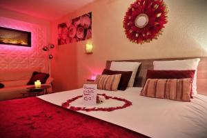 Un dormitorio con una cama con un corazón hecho de rosas en Nuit Romantique avec Jacuzzi à 15 min de Toulouse, en Blagnac