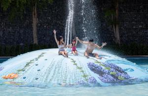 チャアムにあるSO/ Sofitel Hua Hinの偽の滝の上に座っている人々のグループ
