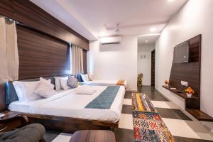 a bedroom with a large bed and a flat screen tv at Hotel Naman in Udaipur