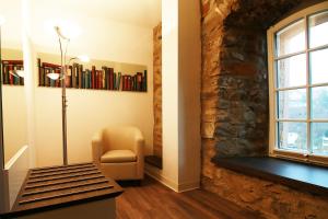 Zimmer mit einer Steinmauer, einem Stuhl und einem Fenster in der Unterkunft Schlosshotel Weilburg in Weilburg