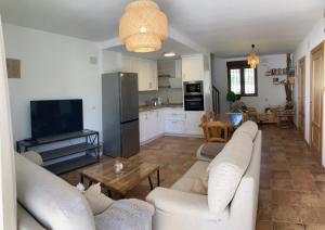 un soggiorno con divani bianchi e una cucina di Cortijo Casita Maray a Dúrcal