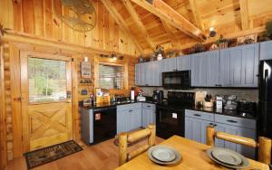 セバービルにあるDancing Bearのテーブルとドアが付いた木製のキャビンのあるキッチン