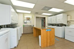 a large laundry room with white appliances and a counter at 21st Floor Renovated Studio with 2 Queen Beds in Honolulu