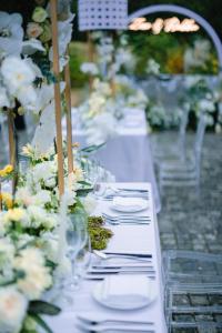 a row of tables with plates and glasses and flowers at Yangshuo Sugar House in Yangshuo +126 photos