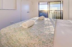 two towels are sitting on top of a bed at Beach Front Abode- 2 Bed 2 Bath in Christchurch