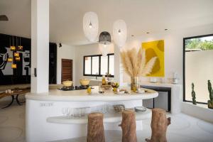 cocina con isla blanca en la sala de estar en Villa Le cerf doré, en Hinkong